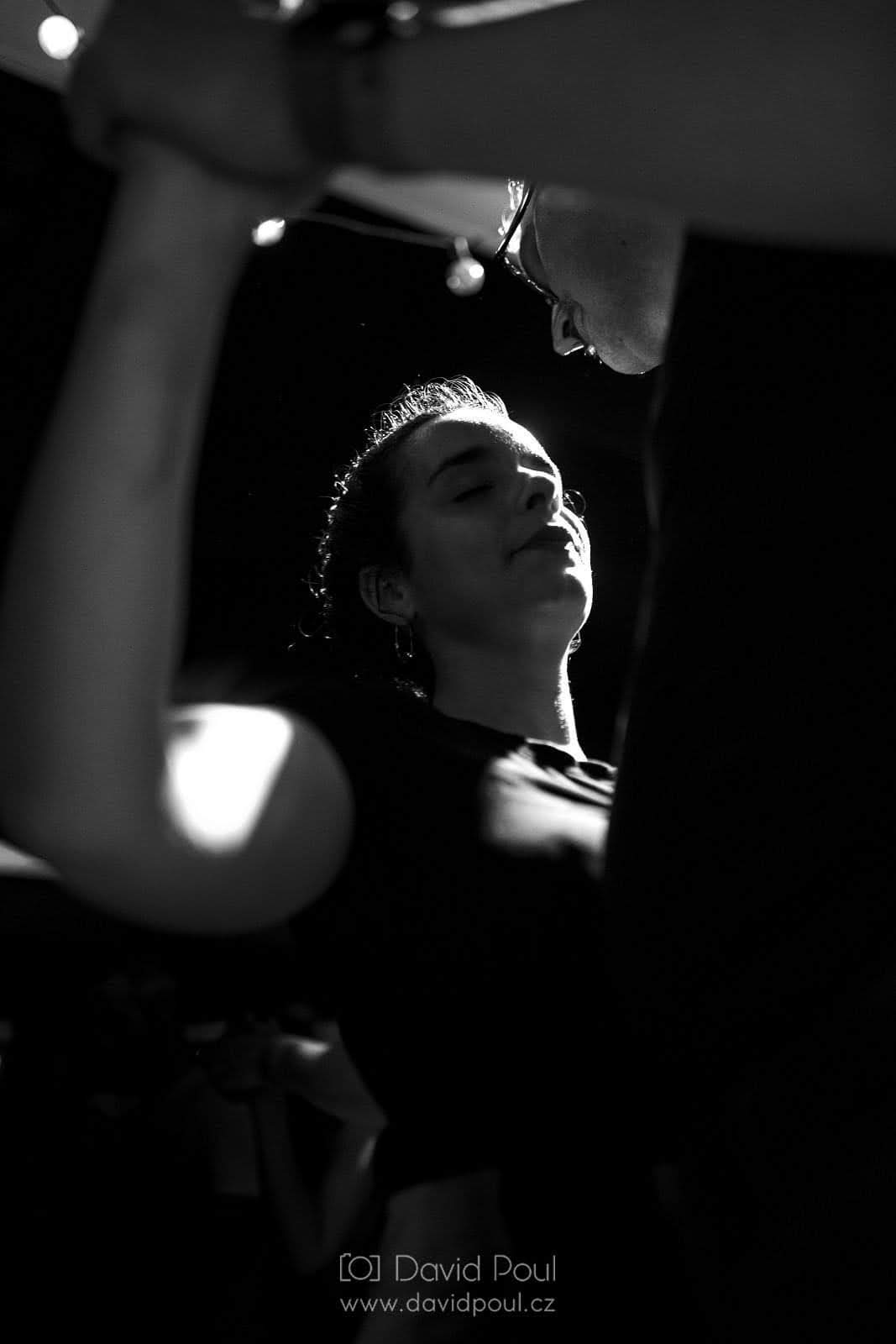 Black-and-white photo of Abigail in a close blues dance embrace, lit from behind