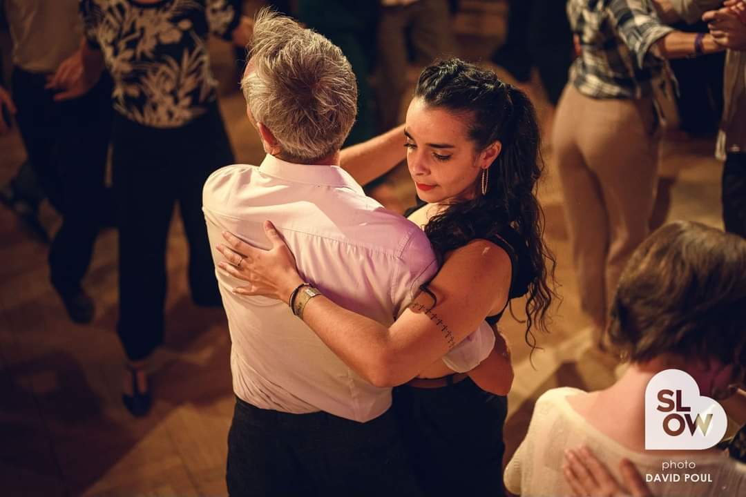 Abigail dancing a close partner dance on a crowded social dance floor